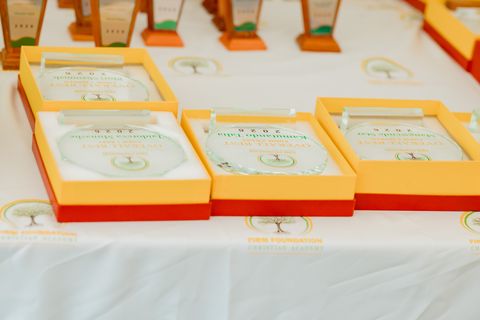 Prize-giving awards on a table displaying the Firm Foundation school logo