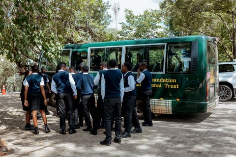 Uniformed learners beside the bus bearing the Firm Foundation name