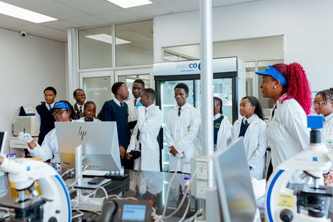 Uniformed learners listening to a laboratory guide during an off-campus CIMAS visit