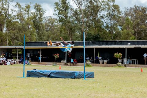 High-jump participation with spectators around the school field